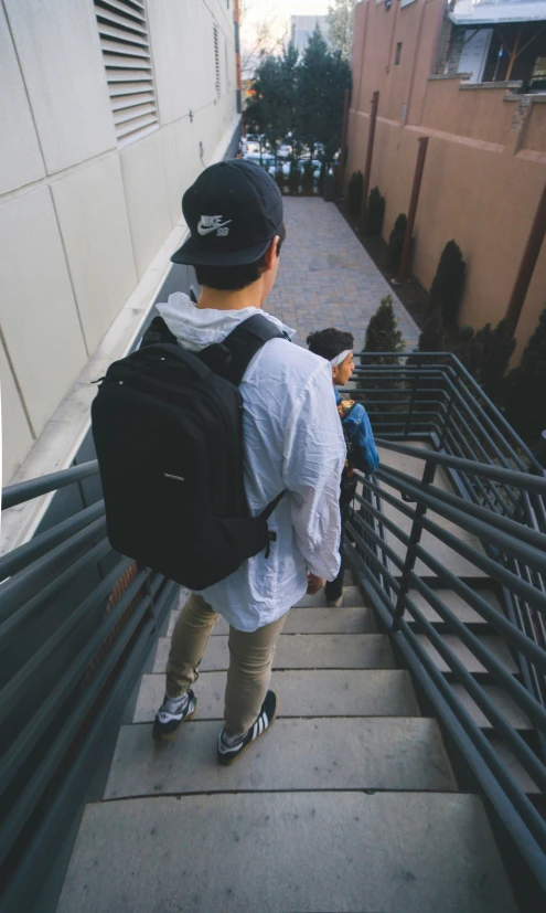 two people on a staircase one in a hat the other in a shirt