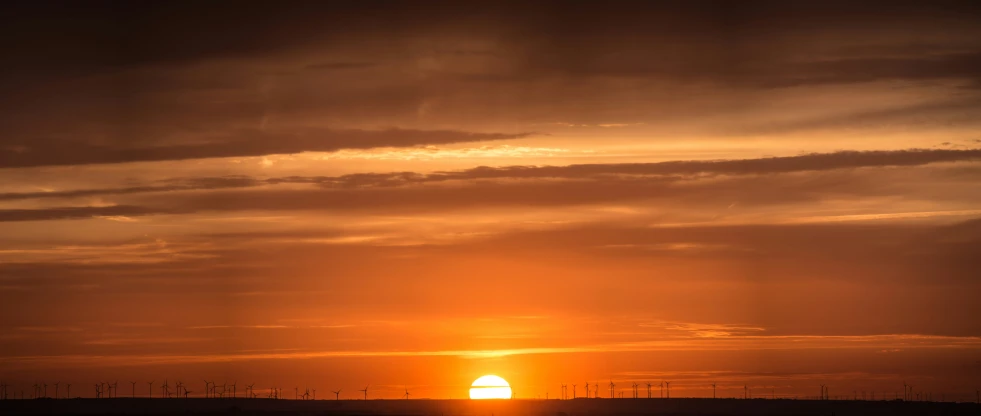 the sun is setting behind the power lines