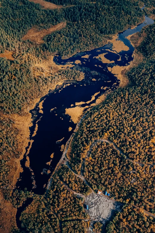 a small lake near an open area of land and trees