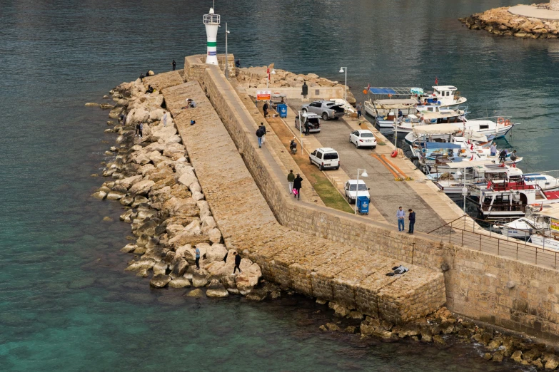 an old concrete pier with several boats docked in a bay