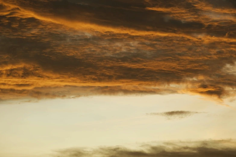 a plane is flying above the clouds during sunset