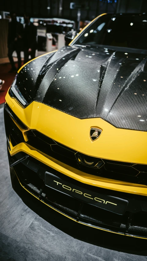 the front of a yellow car in a garage