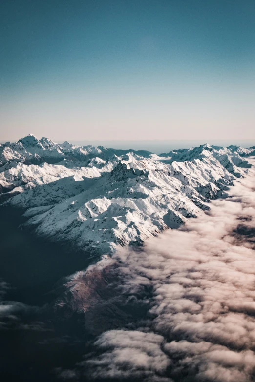 an aerial view from a plane of mountains covered in snow