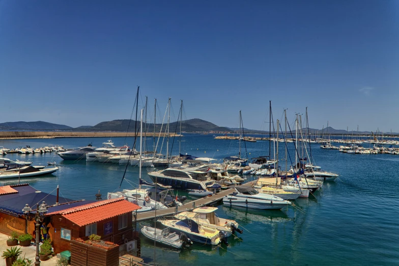 there are many boats in the water next to a pier