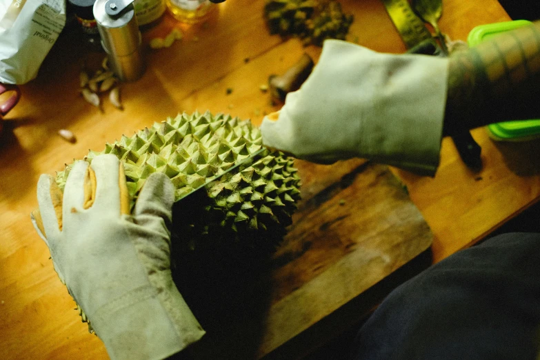 a person is holding up a fruit on a wooden table