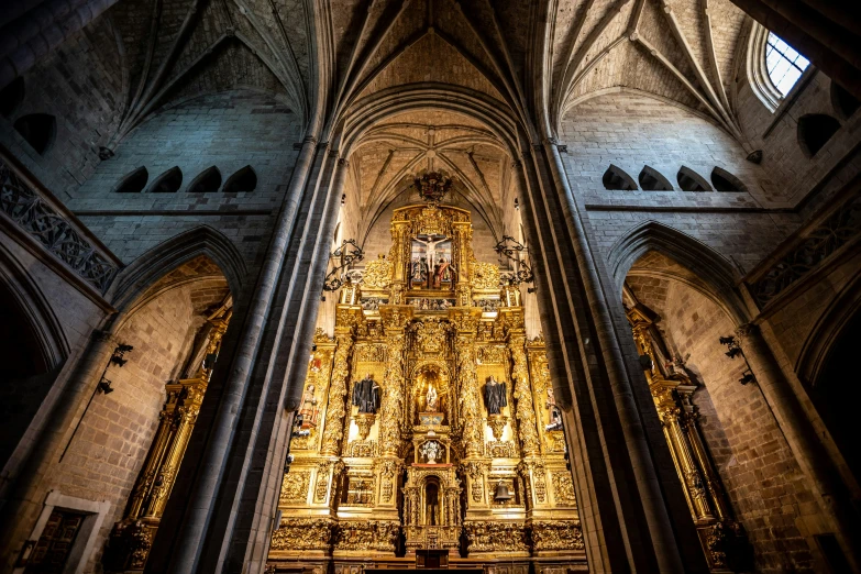 the inside of a cathedral with an ornate gold stain glass window