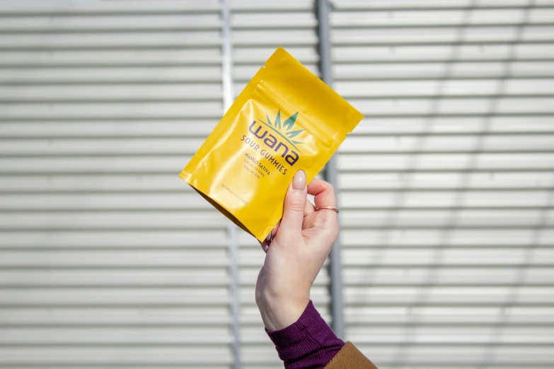 a woman holds an unopened snack on her hand