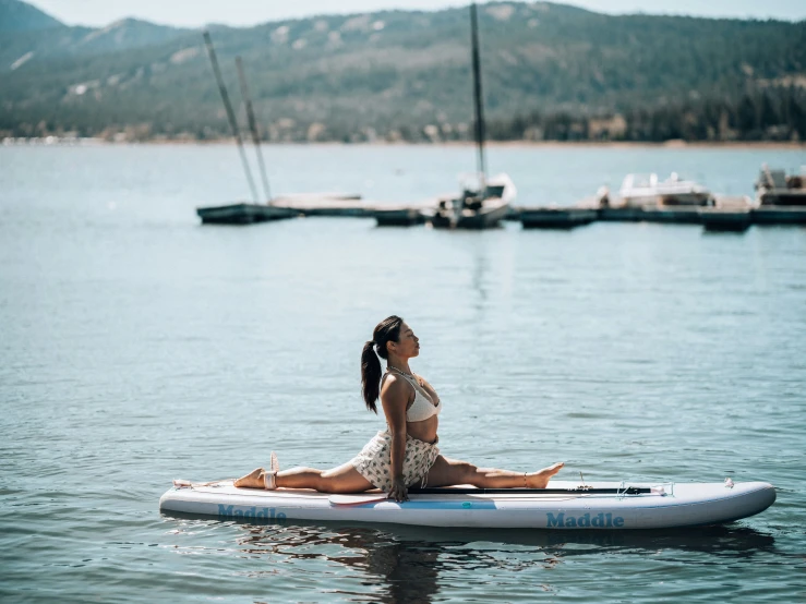 a young woman sits on her suunt on the ocean while water rests nearby