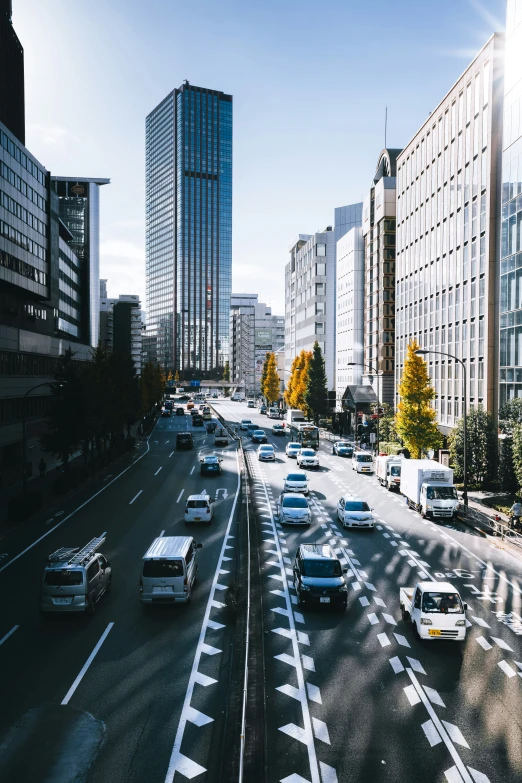 a bunch of cars driving down a highway with tall buildings on either side