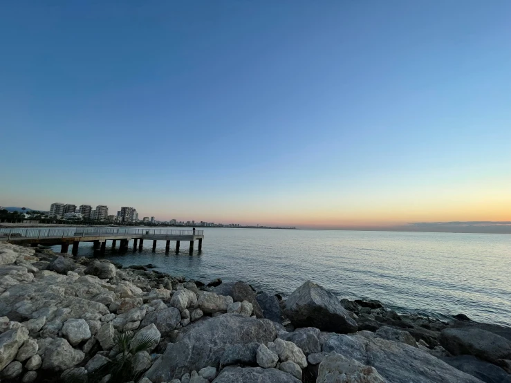 a rocky shore with a pier and water