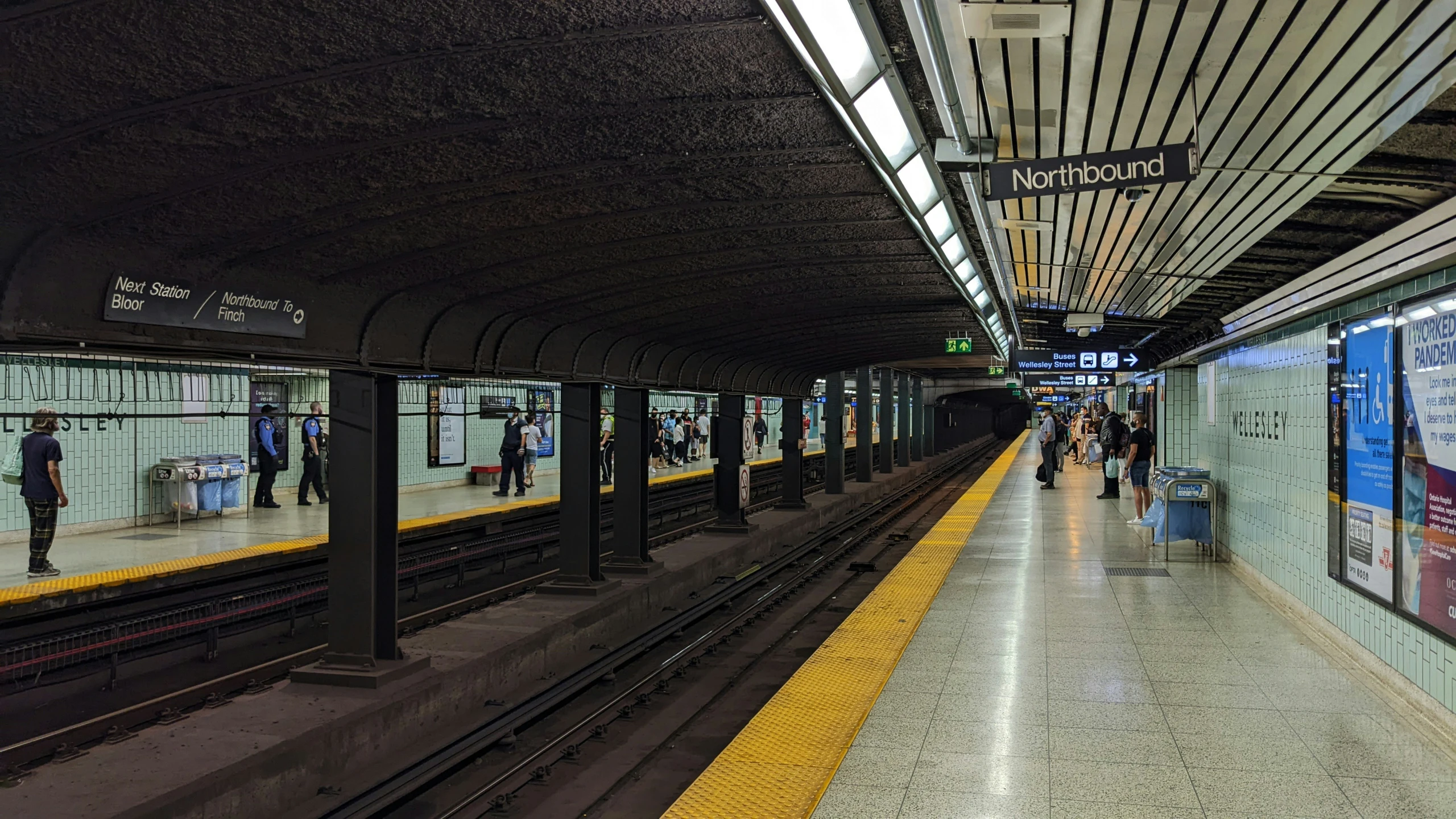 several people at a train station waiting for the train