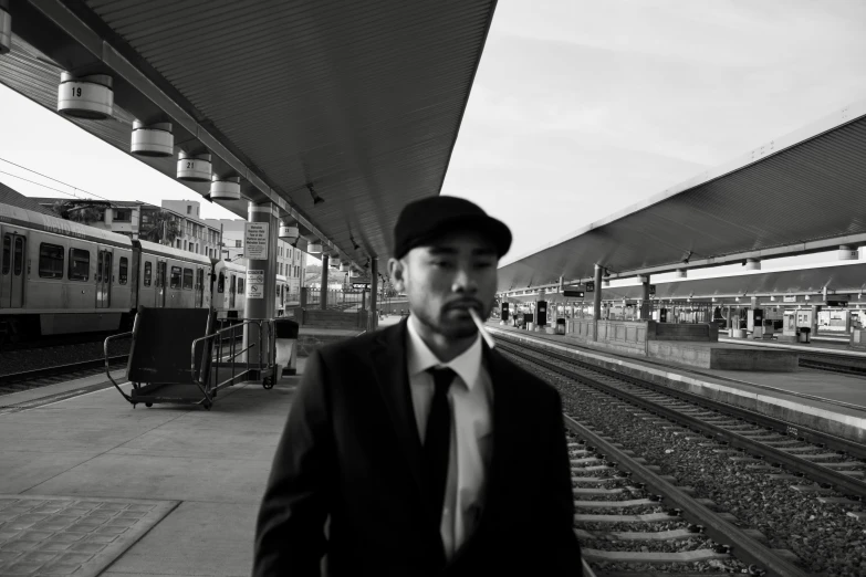 a man standing on the platform with train passing by