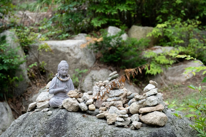 a statue of buddha on top of rocks