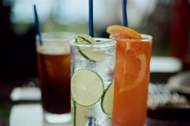 two glasses with a variety of drinks on a table