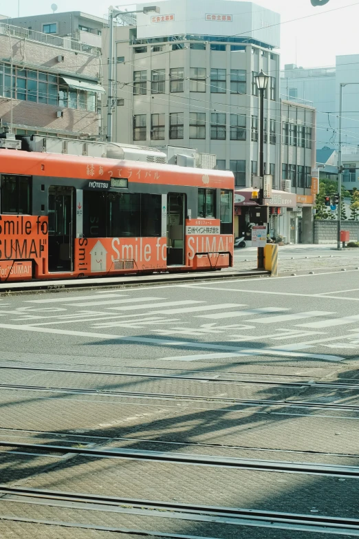 orange bus with advertit sitting in city area