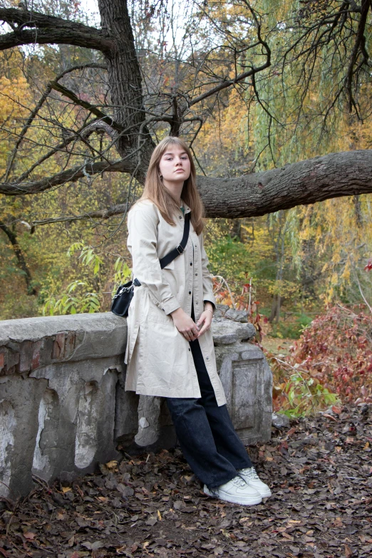 a woman is sitting on a bench in the woods