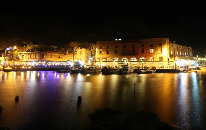 the lights of city buildings are reflecting in the water