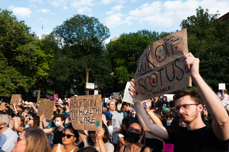 a large crowd of people holding signs in a protest