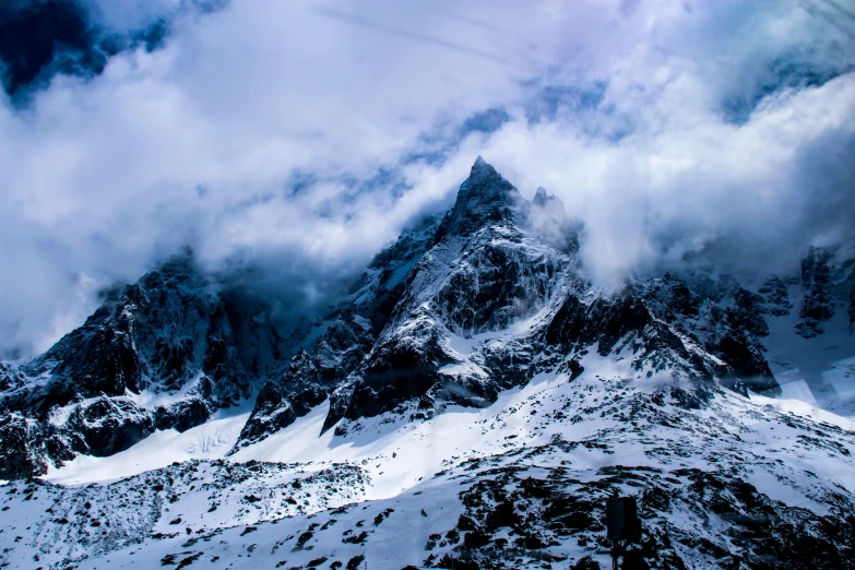 snow covered mountains are in the background as clouds fill the sky