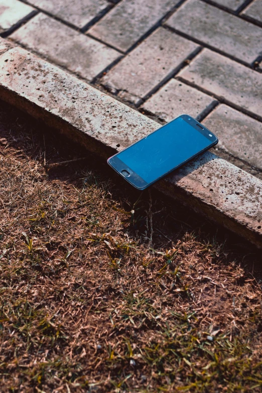 the blue object is laying on the ground near a wall