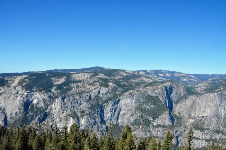 some tall mountains and a few trees on the side