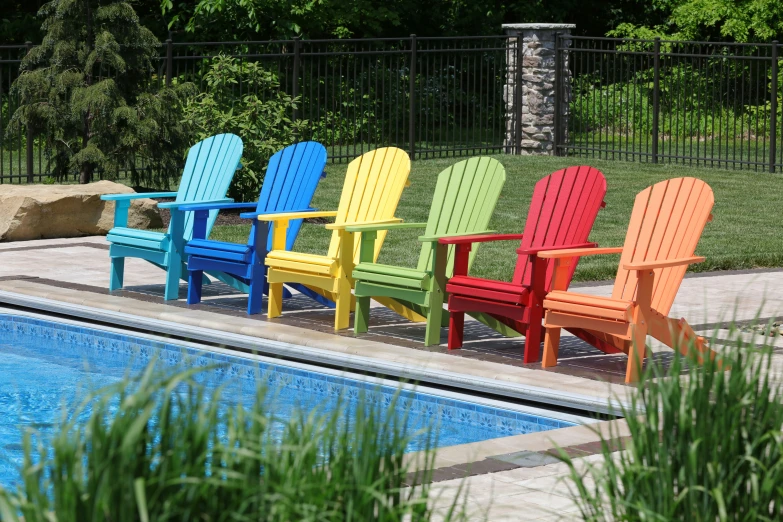 six chairs in different colors near the pool