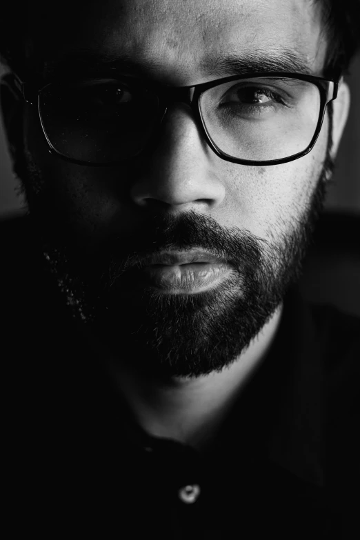 black and white pograph of man with beard and glasses