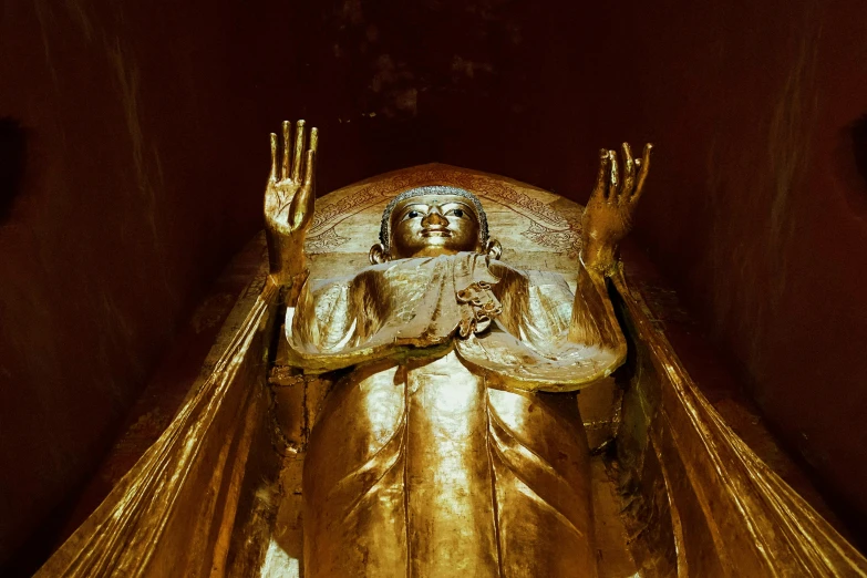 the large gold buddha statue is displayed in front of a wall