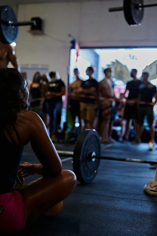 a woman squats down as she performs a deadlift