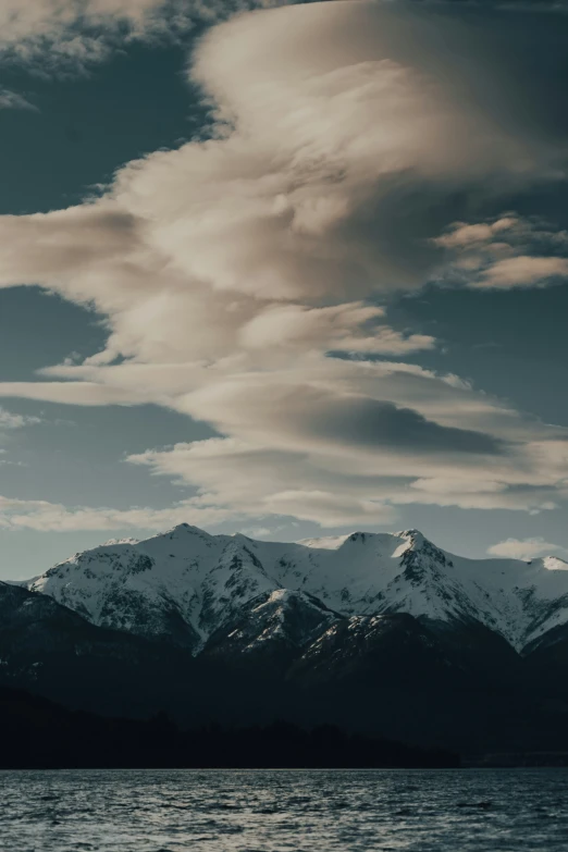 the snow covered mountains rise above the water