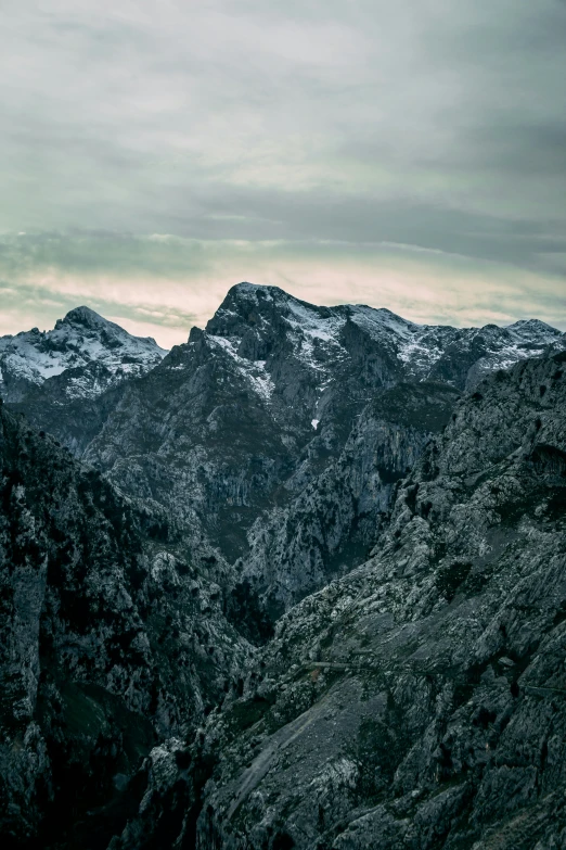 some snow capped mountains under a gray sky