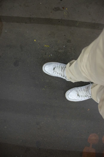 the foot of a person wearing white shoes