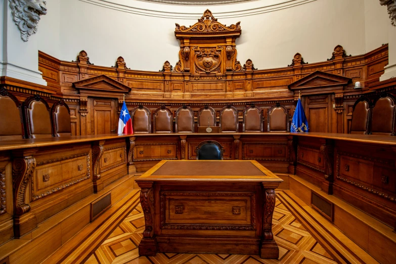 a large wooden courtroom with a desk and chairs