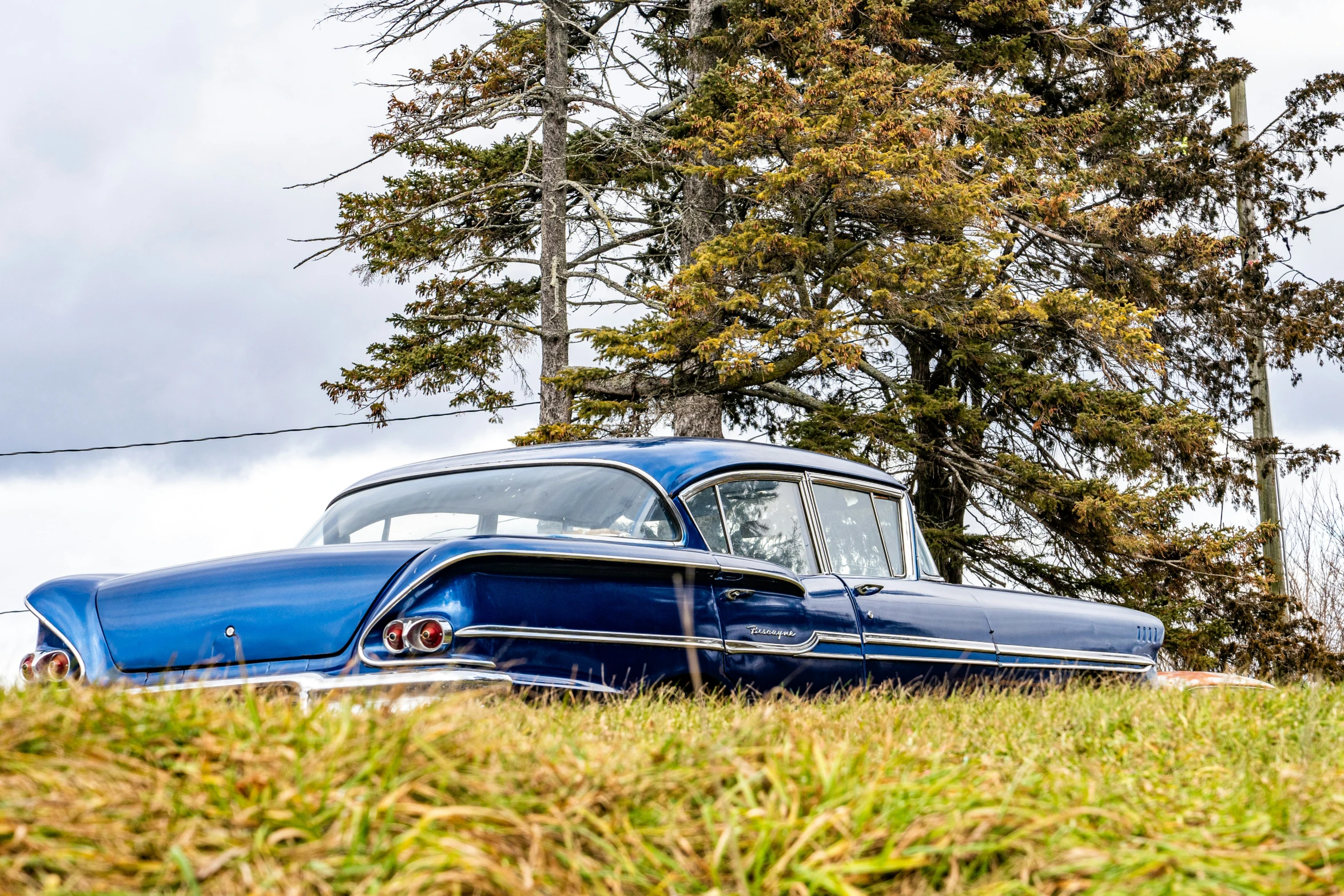 the classic car is parked on the grass