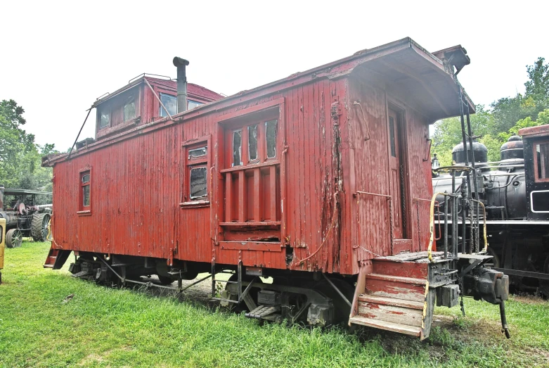 a red and white train caboose on some tracks