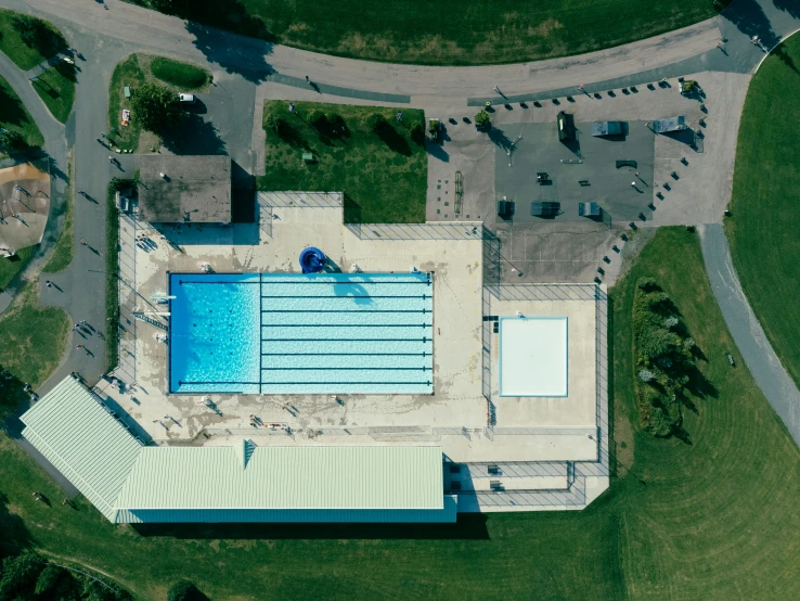 an overhead view of a blue swimming pool in a building