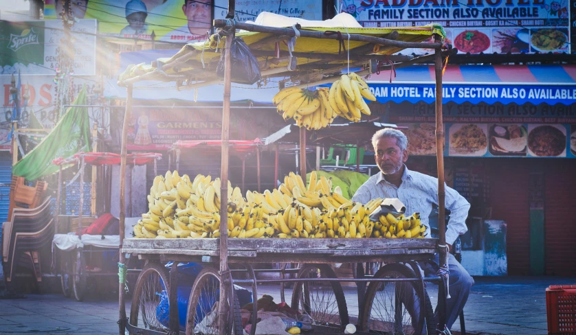 the man is selling bananas on the cart