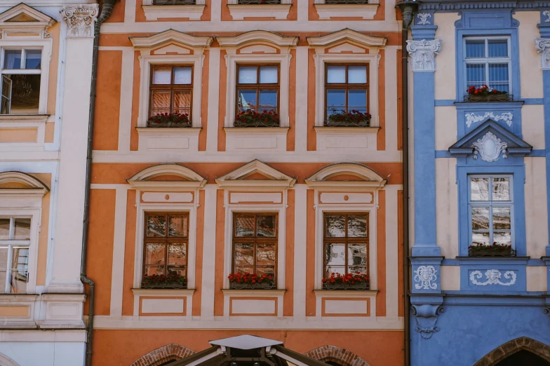 an orange building with multiple balconies with windows