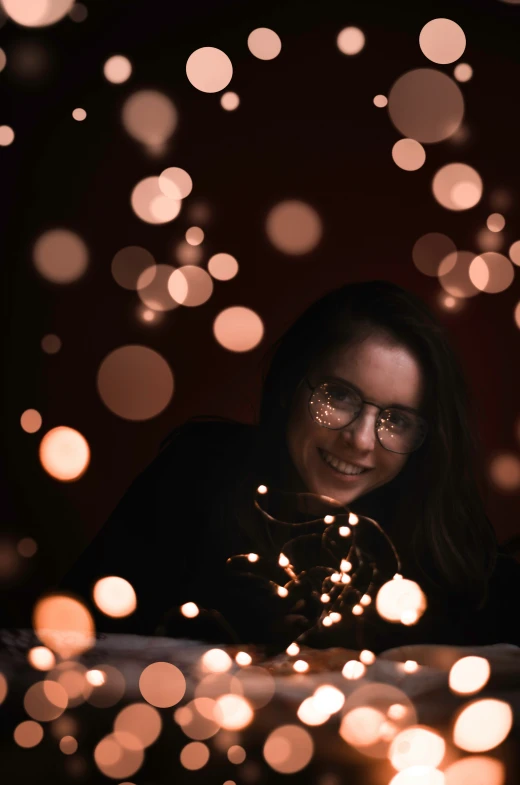 a woman looking down at a string of lights