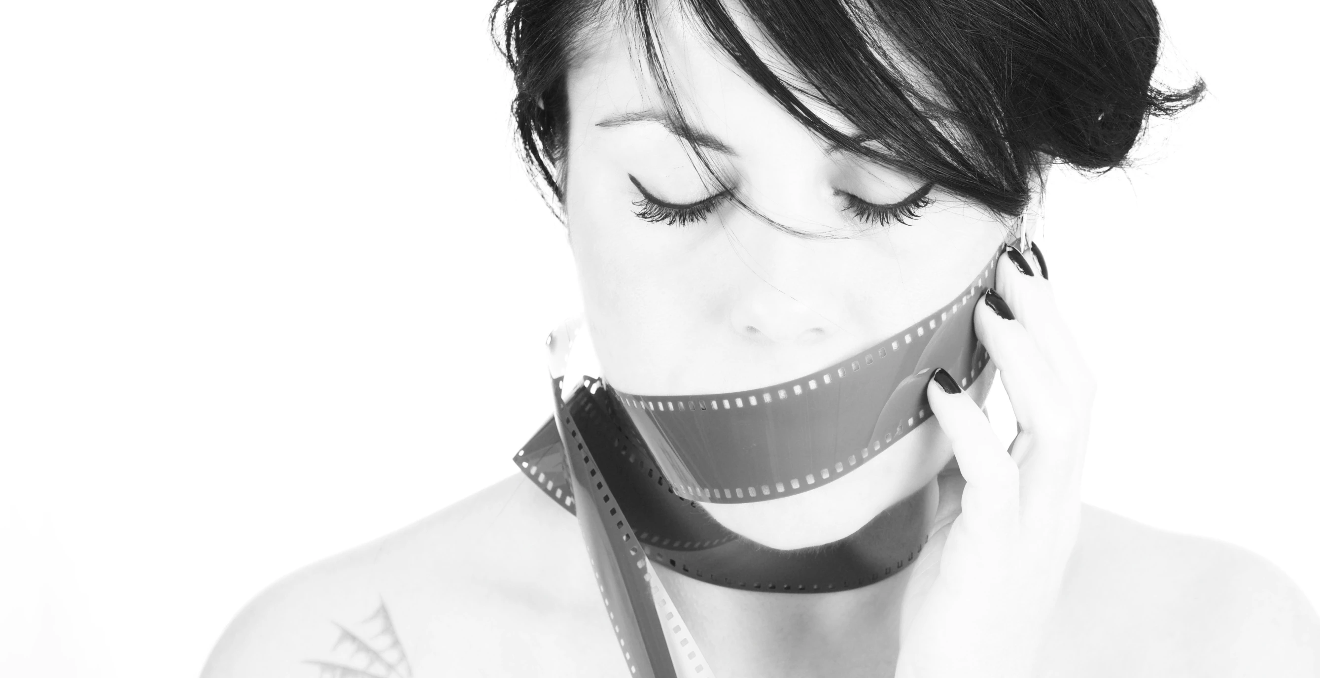 a woman covering her face with a film roll around her neck