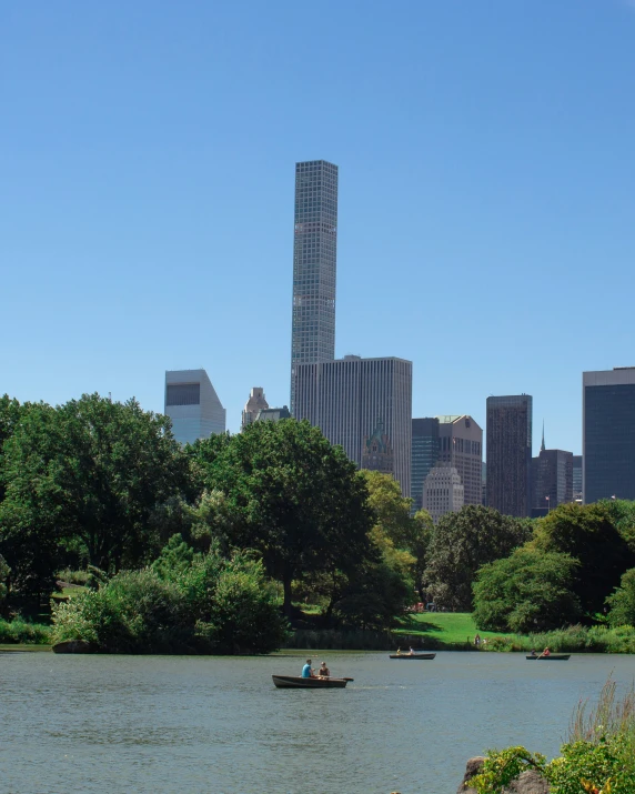 a boat traveling across a river next to tall buildings