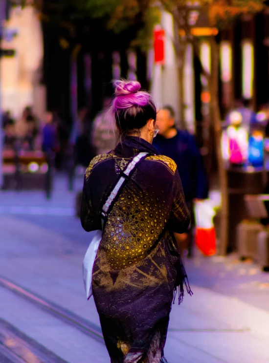 a woman walking down the street carrying a large suitcase