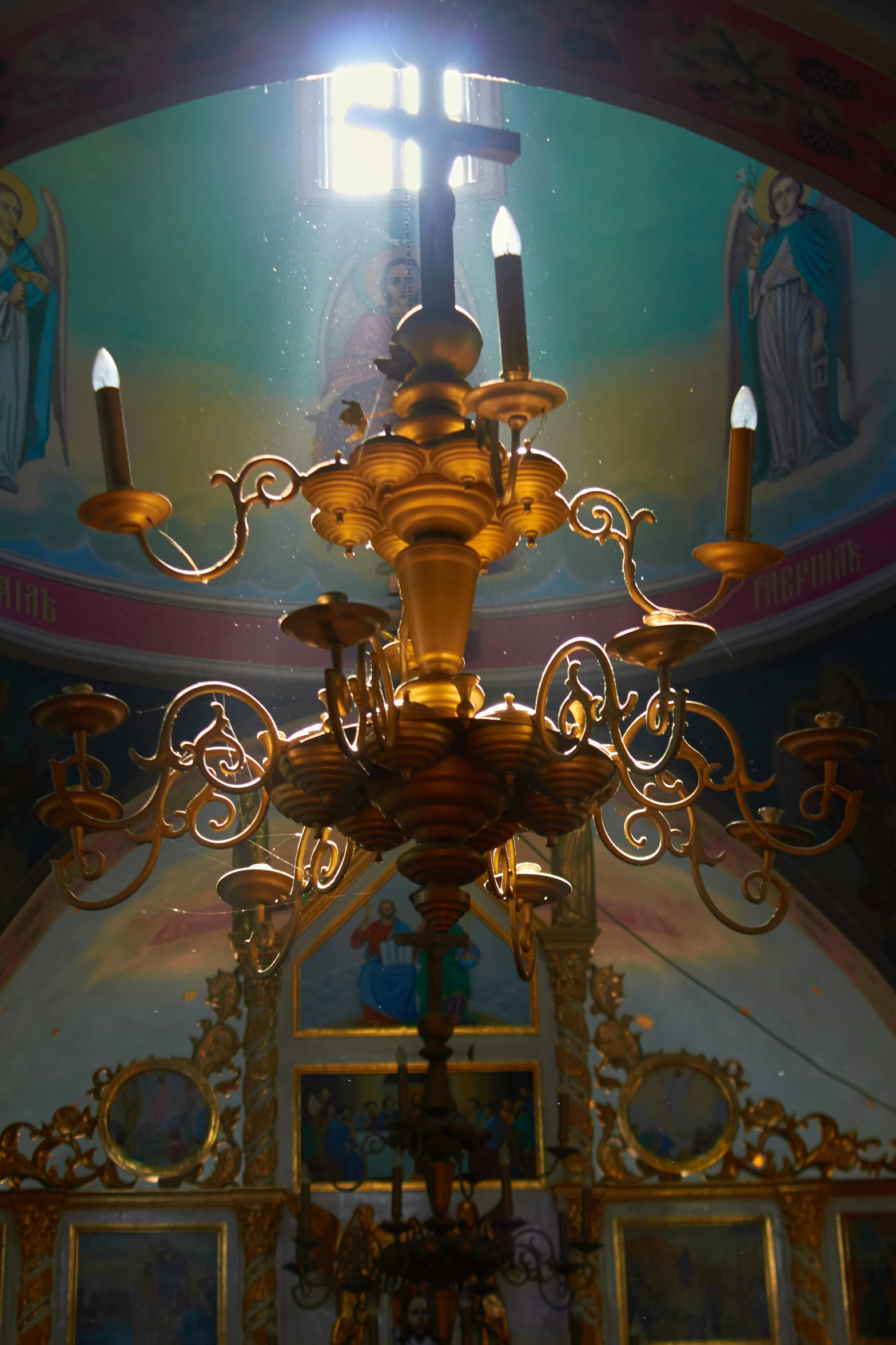 a chandelier hanging from a ceiling next to pictures