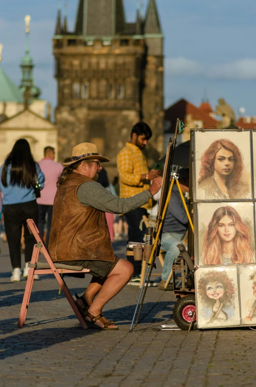 a man kneeling down by easels painting pictures