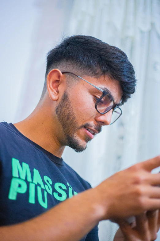 a man in blue shirt looking at his cellphone