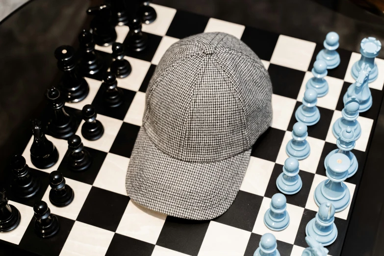 two hats on a checkerboard board next to blue chess pieces