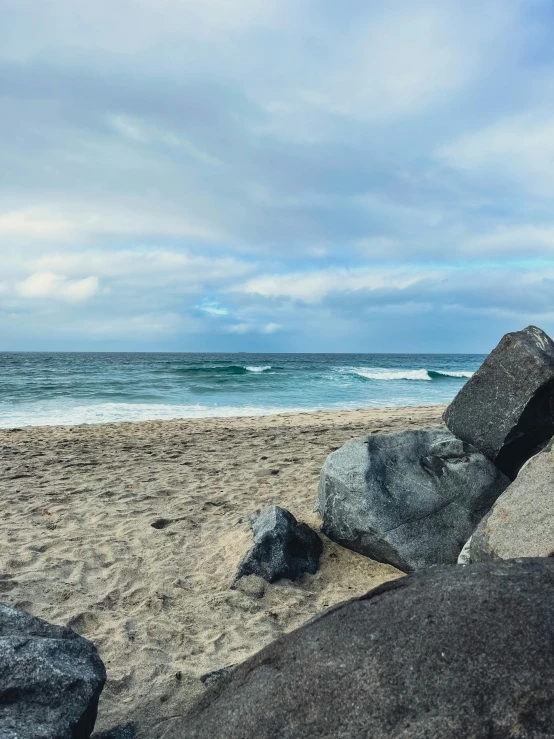 a surfboard sitting on a rock near the ocean