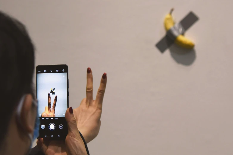 someone taking a picture of a dog jumping from a banana peel