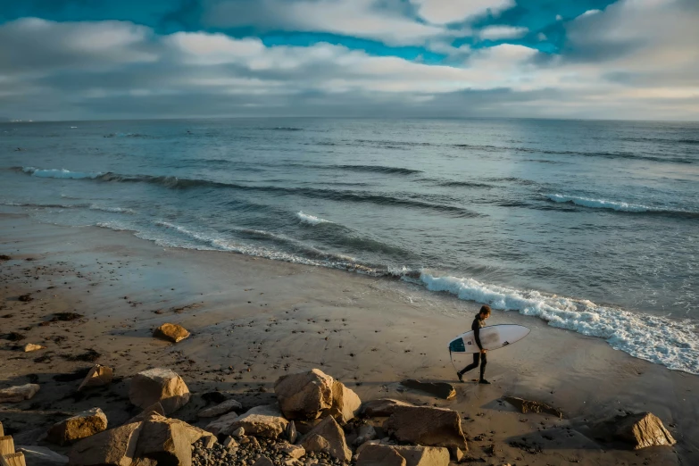 a man on the beach with a surf board