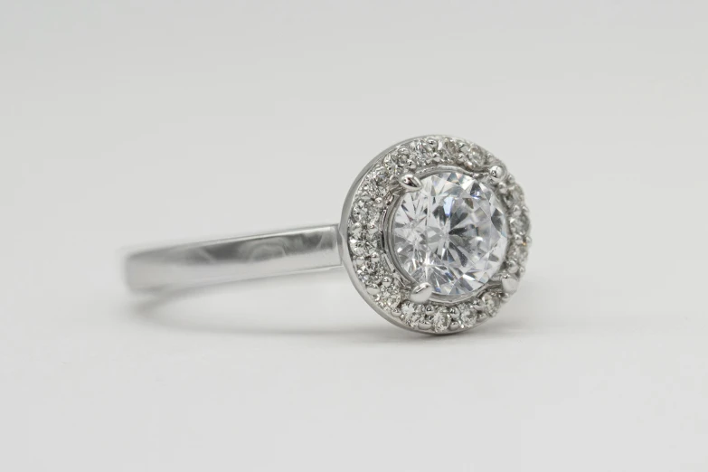 a white diamond ring on a white surface